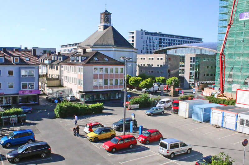 Blick über parkende Autos, im Hintergrund die Karlskirche