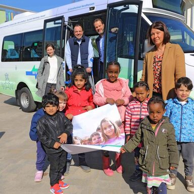 Kinder und Erwachsene vor NVV-Bus