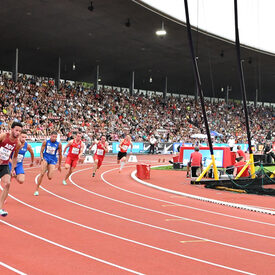 Mehrere Männer laufen im Stadion das 200-Meter-Finale