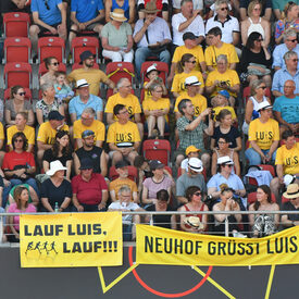 Fans sitzen mit gelben Tshirts im Stadion