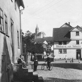 Schwarzweiß Foto von einer Straße, Bäckerei im Hintergrund