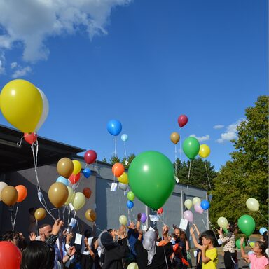 Eine Gruppe Menschen lässt Luftballons steigen