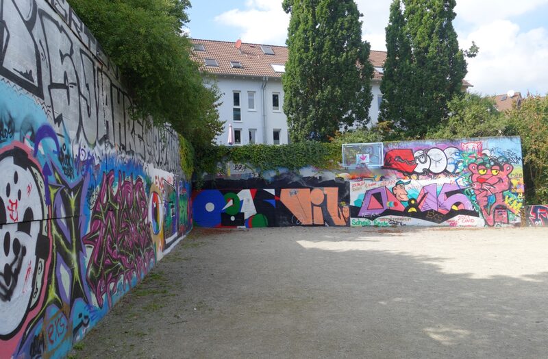 Basketballfeld mit Wänden, an denen Graffiti ist