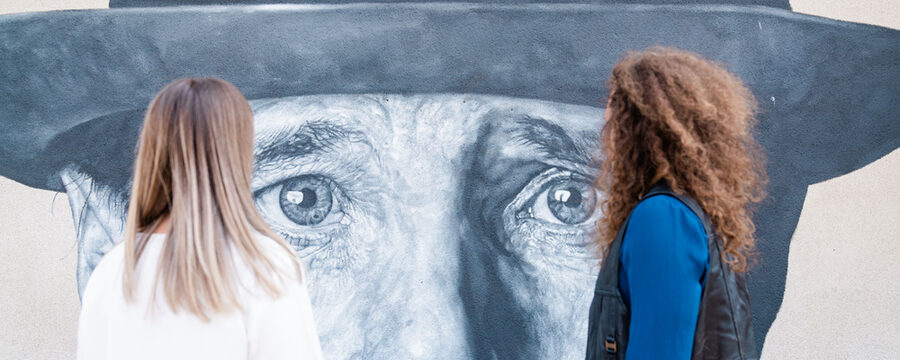 Zwei Personen vor einem Wandbild von Joseph Beuys