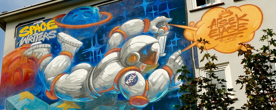 Wandbild Space Writers mit einem Astronauten und einem Flugobjekt