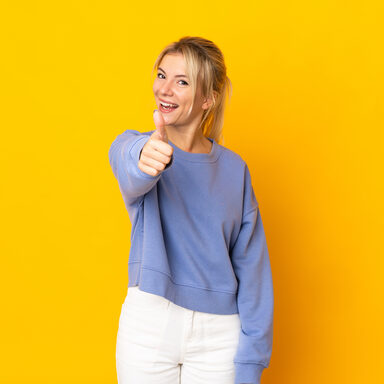 Young Russian woman isolated on yellow background with thumbs up because something good has happened