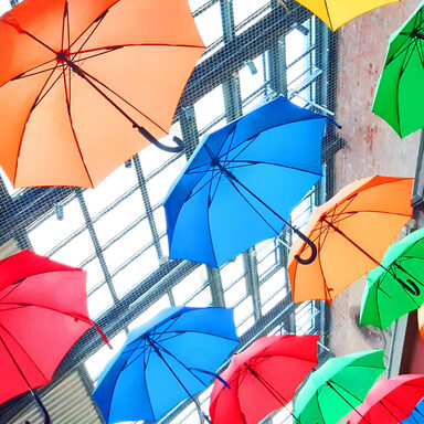 Schirme in den Regenbogenfarben