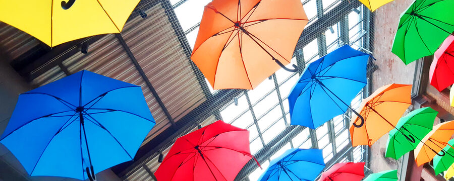 Schirme in den Regenbogenfarben, aufgeklappt und aufgehängt unter dem Dach des Kulturbahnhofs.