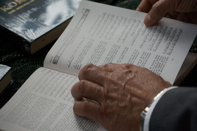 Aufgeschlagener Koran mit Händen