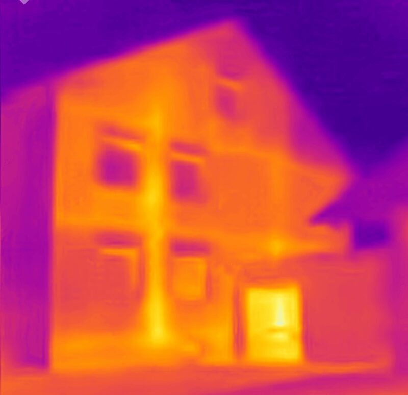 Es ist eine Thermografieaufnahme eines Hauses zu sehen. Kalte Bereiche erschienen violett, warme Bereiche erscheinen rot-orange.