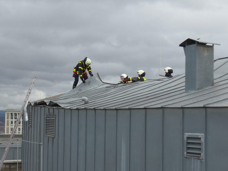 Feuerwehrleute sichern lose Dachteile
