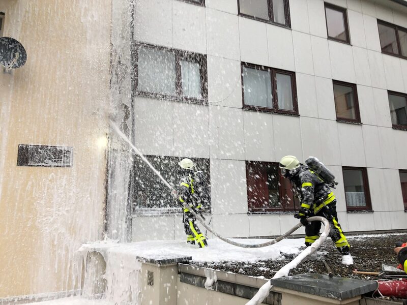 Feuerwehrleute bei Löscharbeiten an einem Gebäude