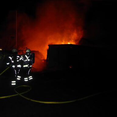 Feuerwehrleute an brennender Gartenhütte
