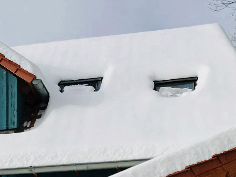 Verschneites Dach mit eingeschneiten Fenstern