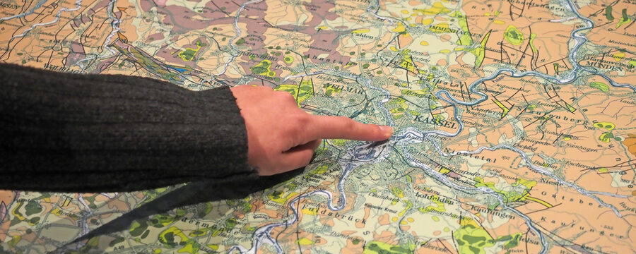 Auf einer Karte mit der Geologie Kassels zeigt ein Finger auf das Stadtgebiet.