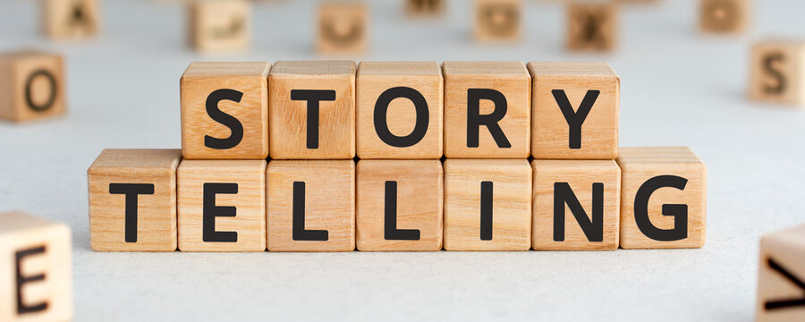 Geschichtenerzählen - Wörter aus Holzblöcken mit Buchstaben, die Kunst, Geschichten zu erzählen, Storytelling-Konzept, zufällige Buchstaben herum, weißer Hintergrund