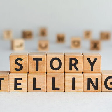 story telling - words from wooden blocks with letters, the art of telling stories storytelling concept, random letters around, white  background