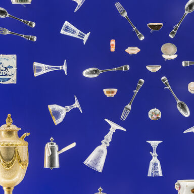 Besteck, Gläser und andere Ornamente sind kreisförmig auf einem blauen Hintergrund angeordnet