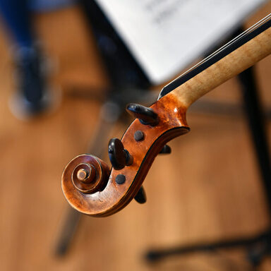 Geigenhals und Noten im Hintergrund