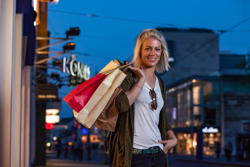 Frau mit Einkaufstaschen beim abendlichen Einkauf