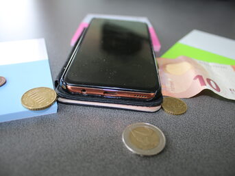 Handy mit Geldschein und Münzen