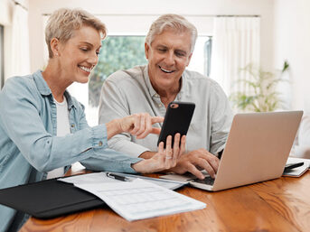 Aufnahme eines älteren Paares, welches Online ihre Anträge stellt.