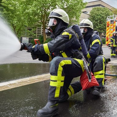 Feuerwehrmann löscht mit Wasser