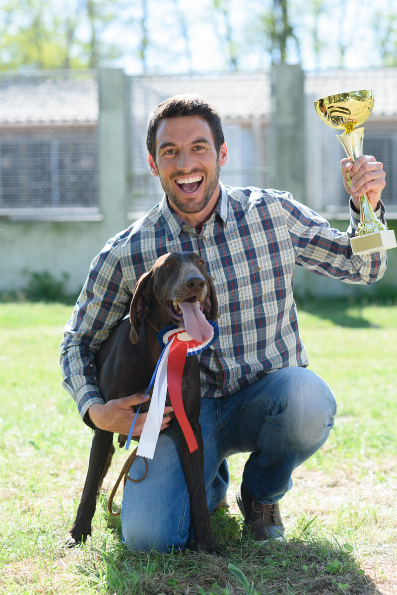 Mann mit Hund und Pokal